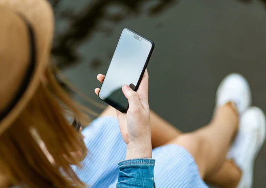 Sitzende Frau mit iPhone in der Hand