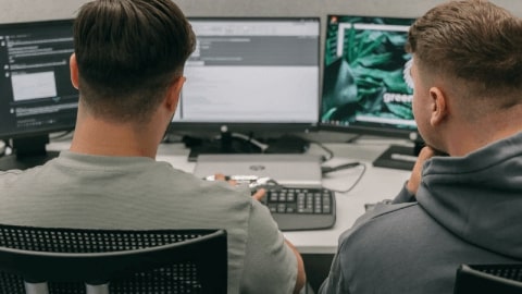 Ein Ausbilder zeigt seinem Auszubildenden Ausbildungsinhalte am Computer