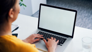 Woman working on laptop mock-up with blank copy space screen